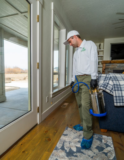 Evade Pest Management technician performing pest control treatment inside of home